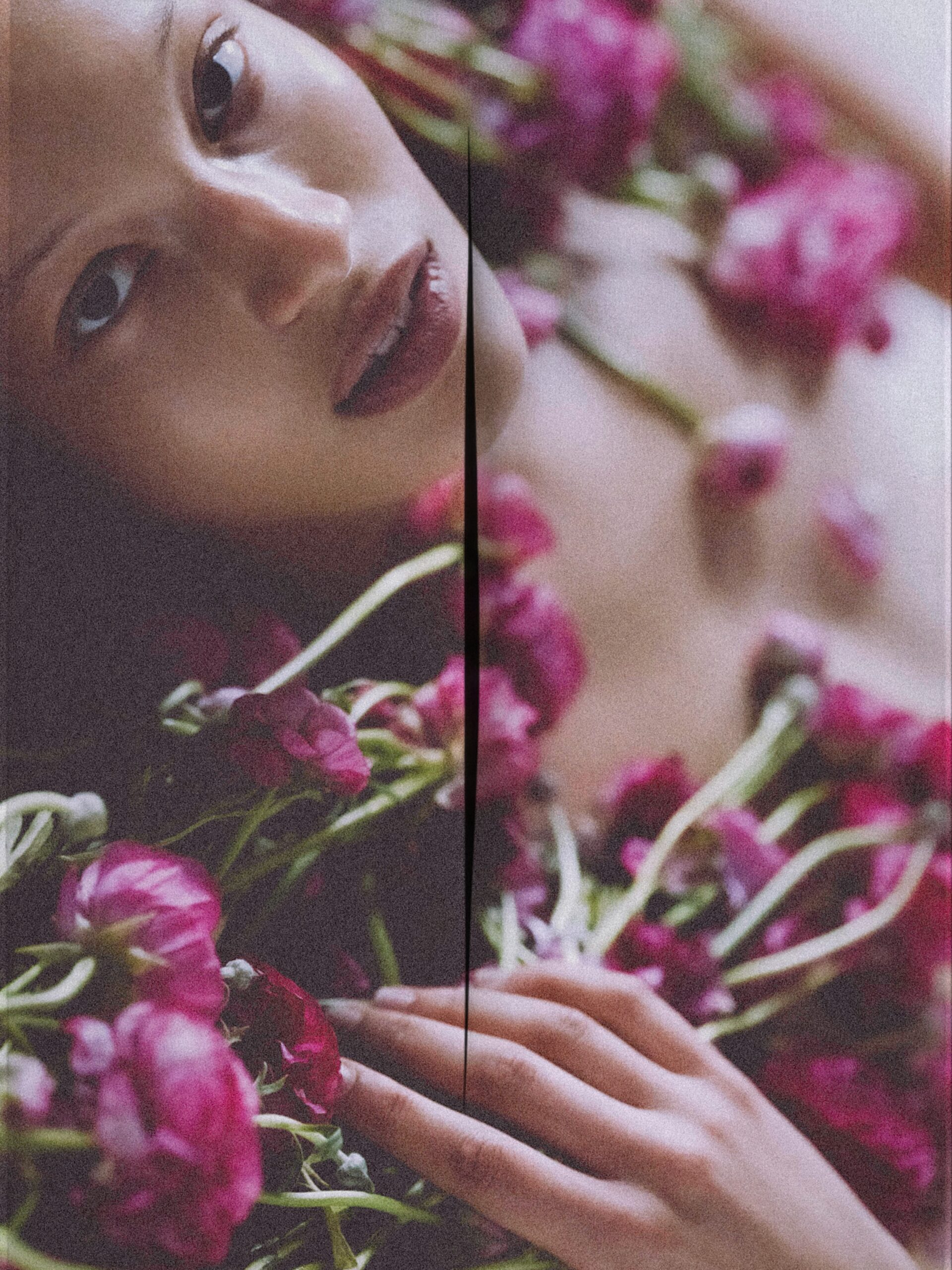 beautiful model Elsa laying on a bed with flowers around her