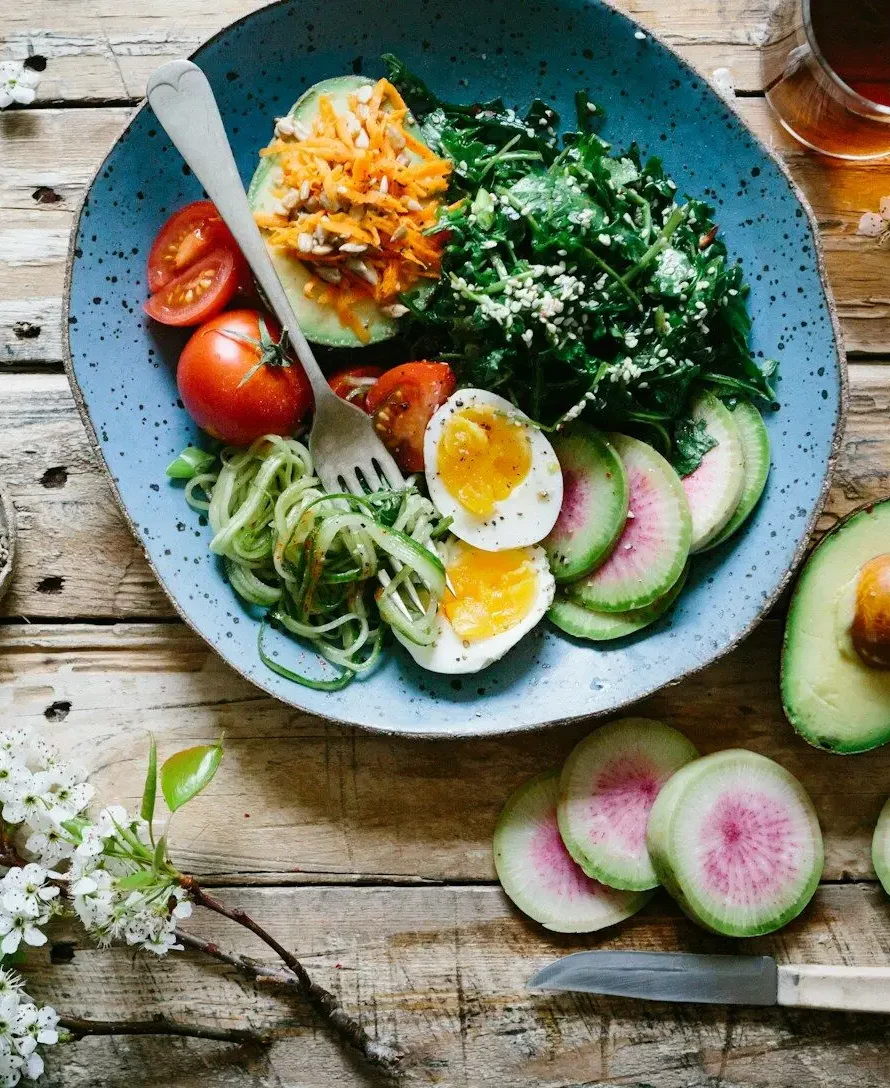 poached egg with vegetables and tomatoes on blue plate